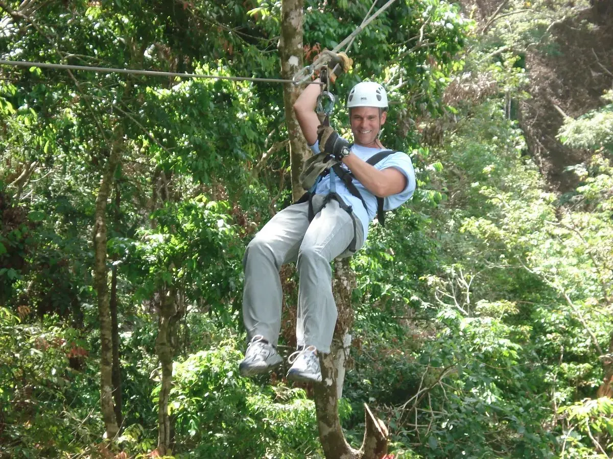 Zip line canopy tour rider crossing rainforest in Costa Rica illustrative photo